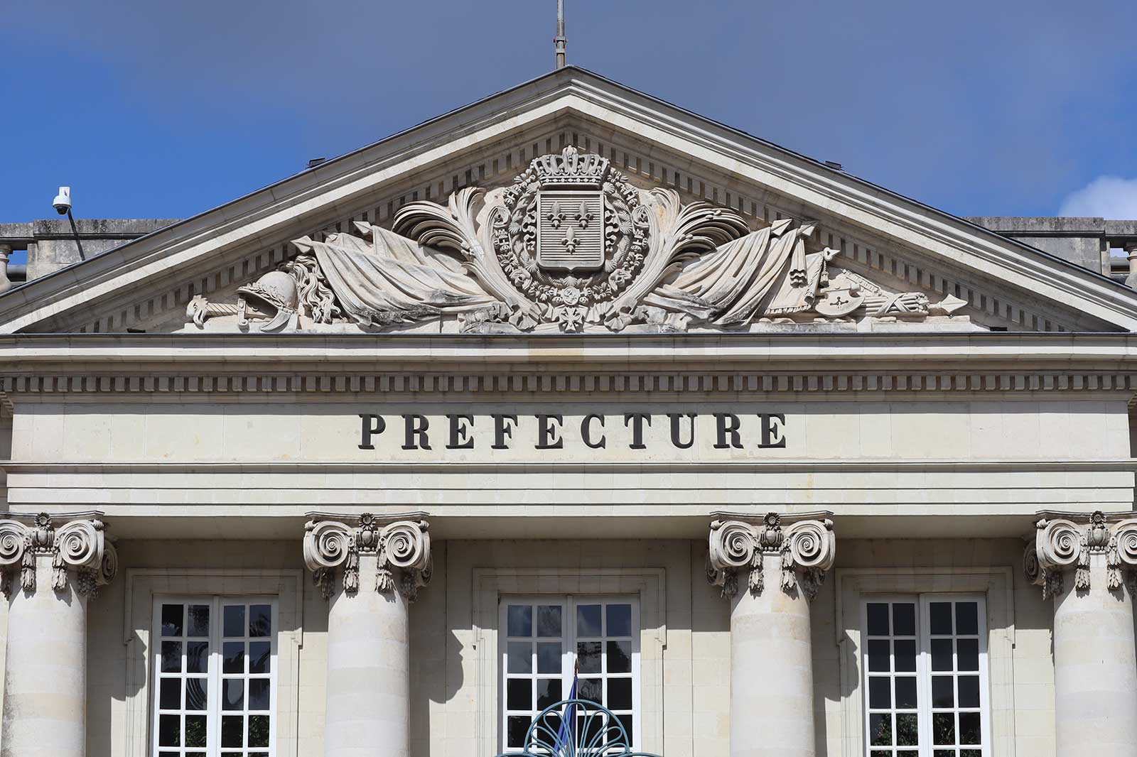 The facade of a building with the word 'PREFECTURE' and ornamental sculptures.