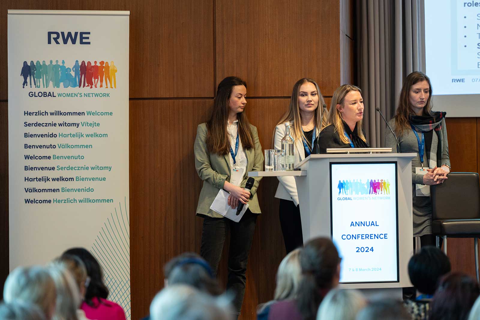 A group of women stands at a podium during the RWE Global Women's Network annual conference 2024.